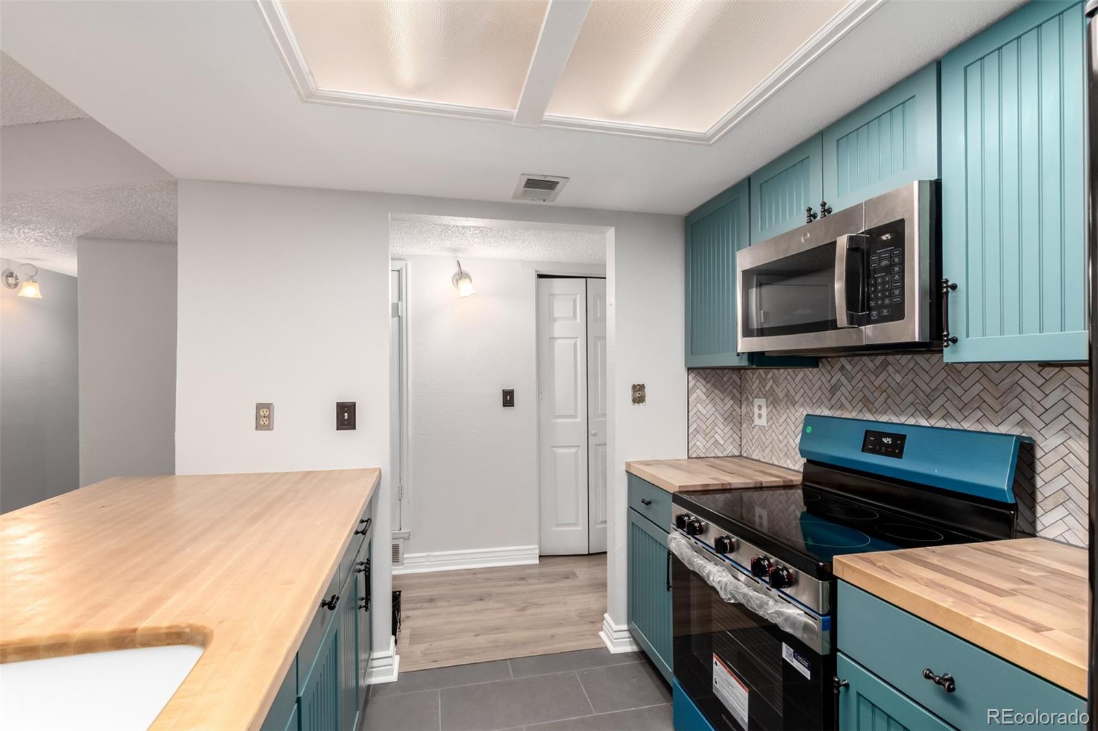 401 South Kalispell Way, Unit 104 Aurora, CO 80017 - Photo 9 of 29 a kitchen with stainless steel appliances a stove microwave and refrigerator