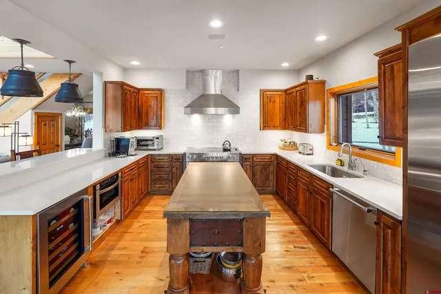 a kitchen with stainless steel appliances granite countertop a sink a stove top oven a counter space and cabinets