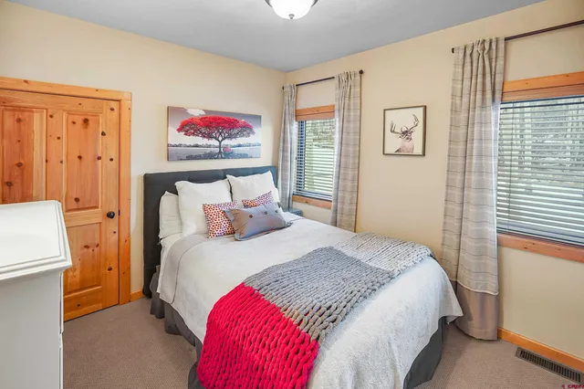 a bedroom with a bed and a painting on the wall