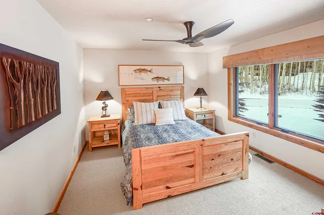 a bedroom with a bed and large windows