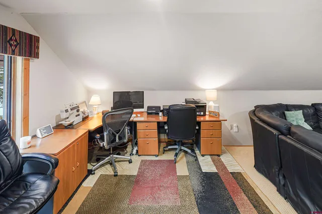 a view of a workspace with furniture and wooden floor