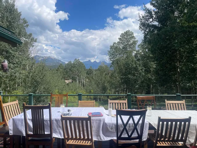 a view of a roof deck with two chairs and a table