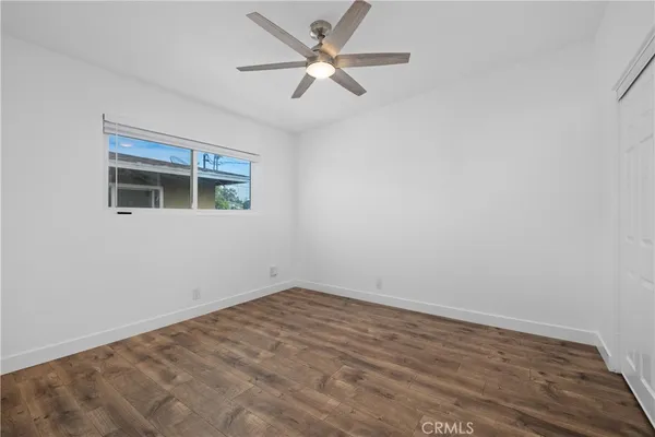 a view of an empty room with a ceiling fan and a window