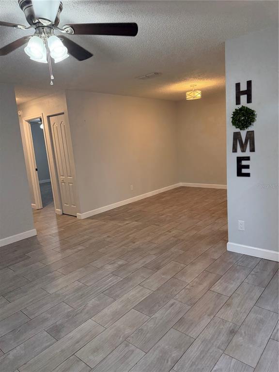 2701 Northeast 10th Street, Unit 802 Ocala, FL 34470 - Photo 3 of 16 an empty room with wooden floor fan and windows