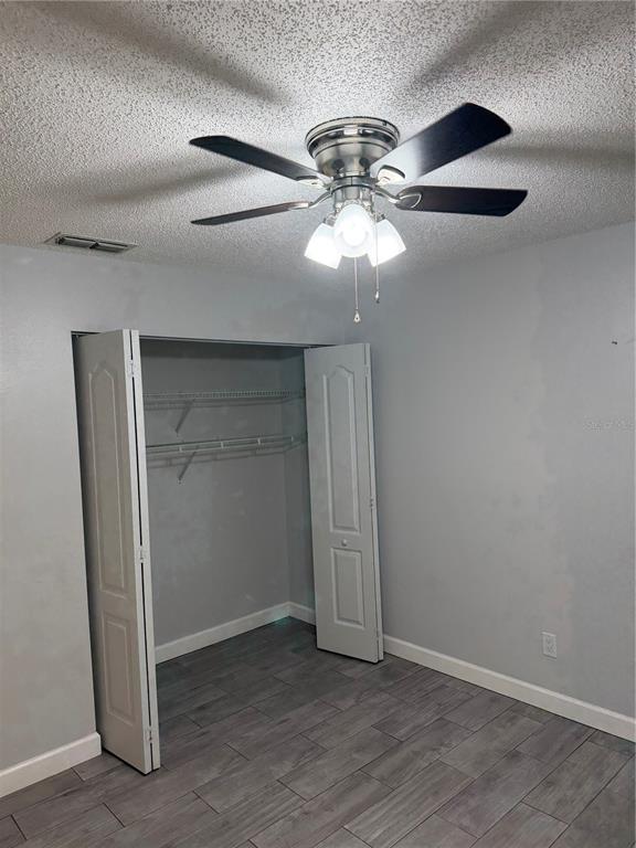 2701 Northeast 10th Street, Unit 802 Ocala, FL 34470 - Photo 7 of 16 an empty room with a chandelier fan and wooden floor