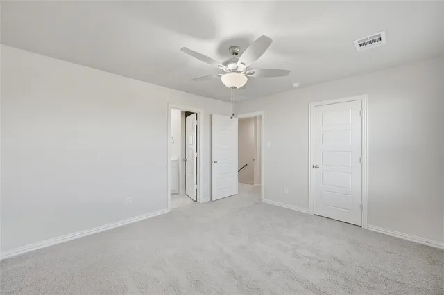 an empty room with a ceiling fan and a window