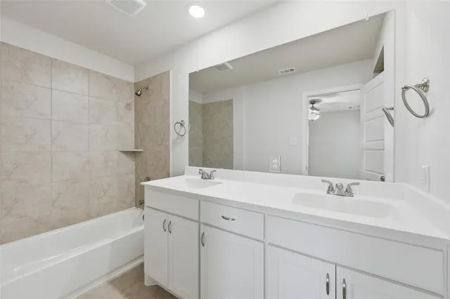 a bathroom with a sink double vanity granite tub shower and a mirror