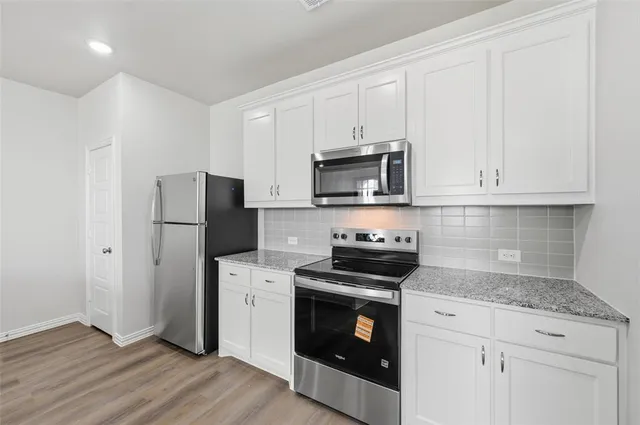 a kitchen with stainless steel appliances granite countertop a stove a refrigerator and a microwave