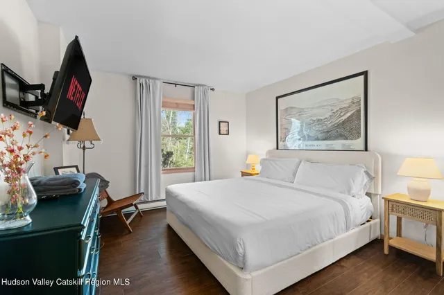 a bedroom with a bed and a flat screen tv