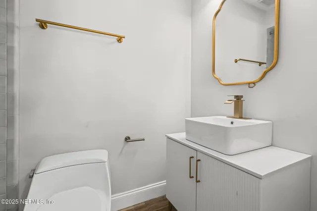 a bathroom with a toilet a sink and mirror