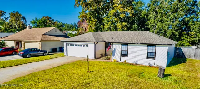 a front view of a house with yard and garage