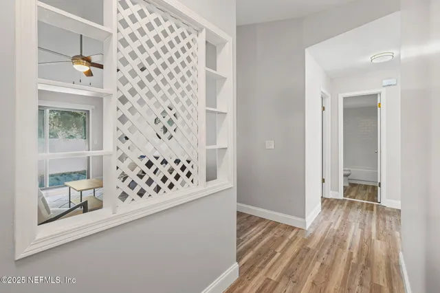 a view of a hallway with wooden floor and staircase