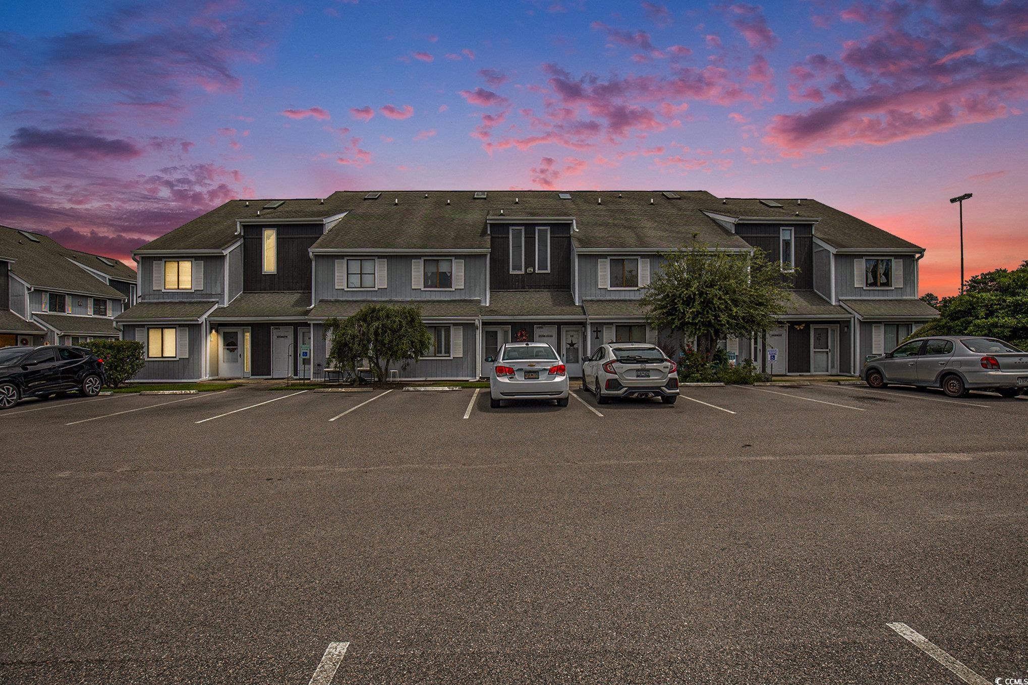 View of property featuring uncovered parking