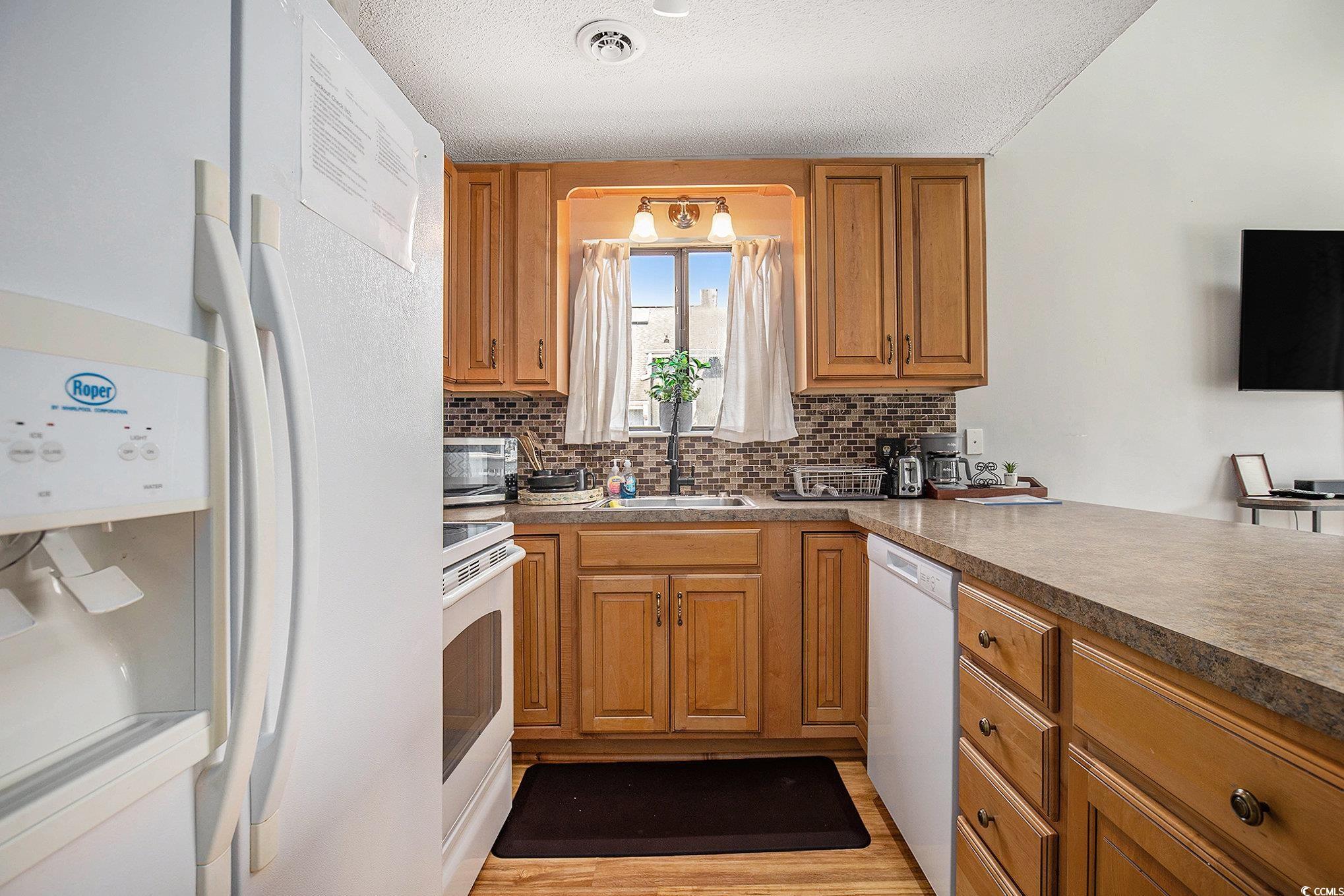 3700 Golf Colony Lane, Unit 14P Little River, SC 29566 - Photo 16 of 30 Kitchen with white appliances, brown cabinets, dec