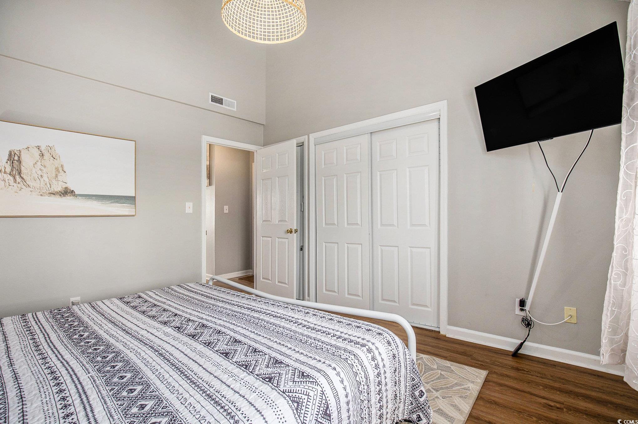 3700 Golf Colony Lane, Unit 14P Little River, SC 29566 - Photo 19 of 30 Bedroom with dark wood-type flooring, a towering c