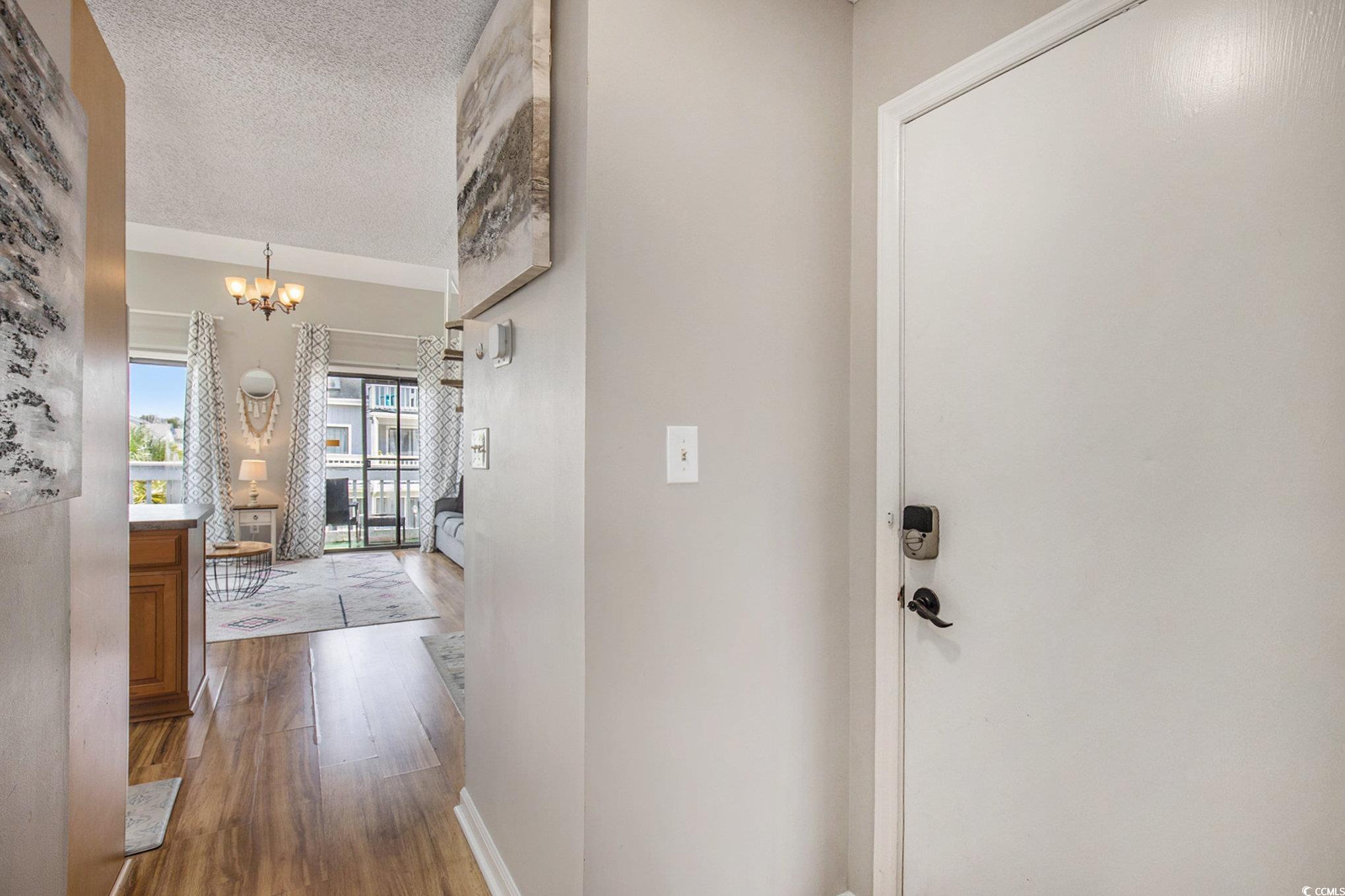 3700 Golf Colony Lane, Unit 14P Little River, SC 29566 - Photo 6 of 30 Corridor with dark wood finished floors, a chandel