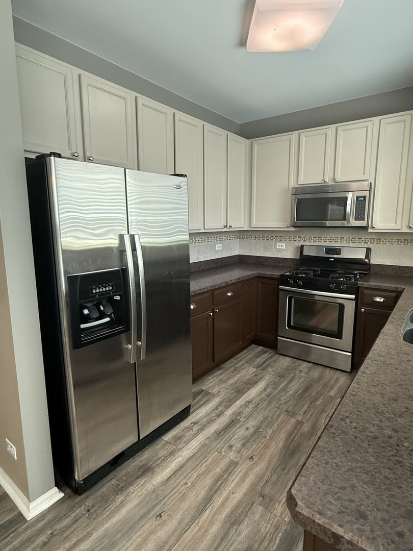 2340 Hudson Circle Aurora, IL 60502 - Photo 10 of 37 a kitchen with stainless steel appliances granite countertop a stove a sink and a refrigerator