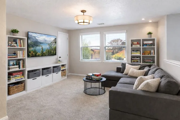 a living room with furniture a flat screen tv and a floor to ceiling window