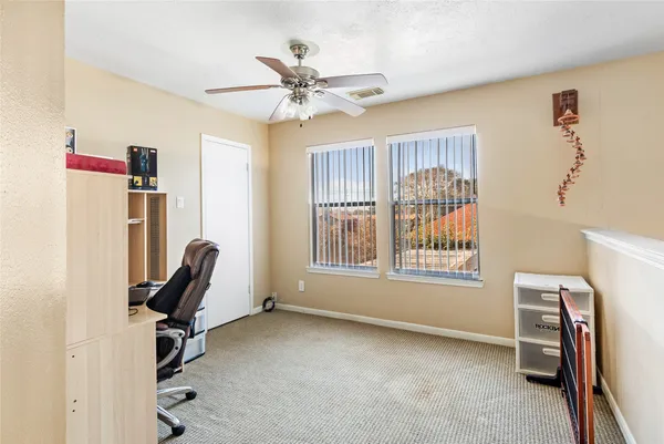 a view of a workspace with furniture and a window