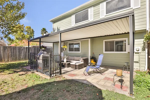 a view of a patio with a table and chairs and wooden fence
