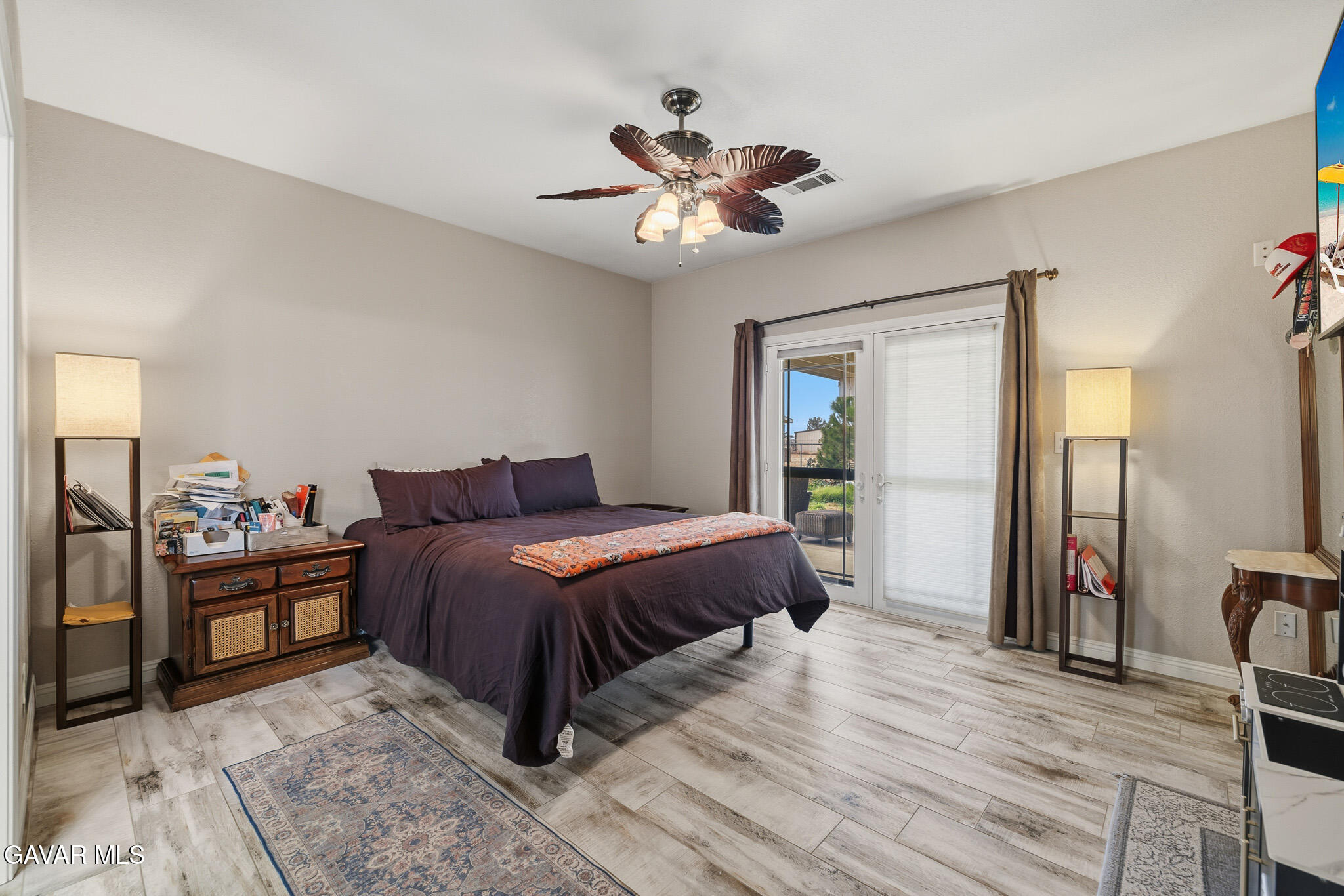 49945 80th Street West Lancaster, CA 93536 - Photo 15 of 38 a spacious bedroom with a bed and a chandelier