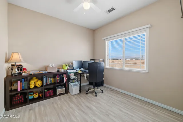 a view of a workspace with furniture and a window