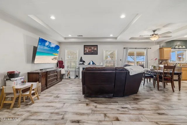 a living room with furniture a flat screen tv and a dining table