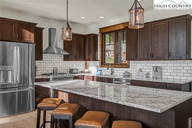 a kitchen with granite countertop a sink stove and refrigerator