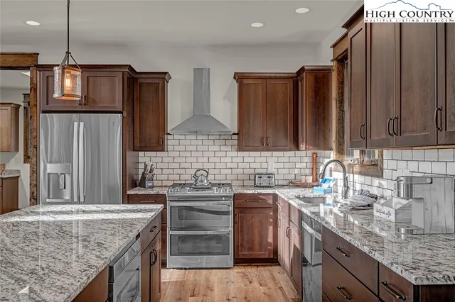 a kitchen with stainless steel appliances granite countertop a sink stove and refrigerator
