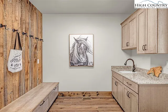 a kitchen with stainless steel appliances granite countertop a sink and a stove with wooden floor