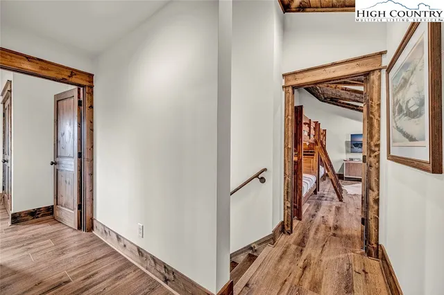 a view of a hallway with wooden floor and stairs