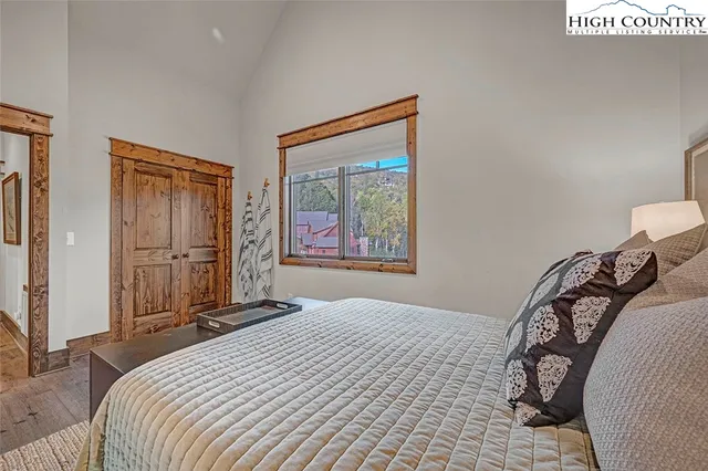 a bed sitting in a bedroom next to a window with chair