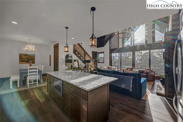 a dining hall with stainless steel appliances granite countertop a stove and chairs