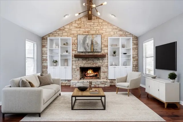 a living room with furniture a flat screen tv and a fireplace