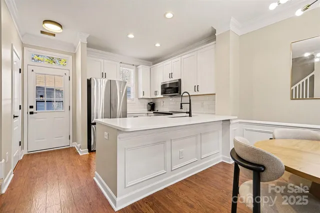 a kitchen with refrigerator cabinets and wooden floor