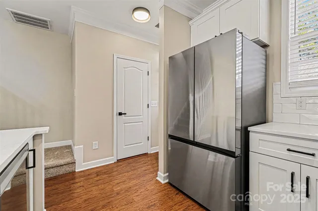 a view of a kitchen with wooden floor and electronic appliances