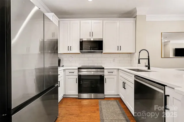 a kitchen with stainless steel appliances granite countertop a stove a sink and a refrigerator