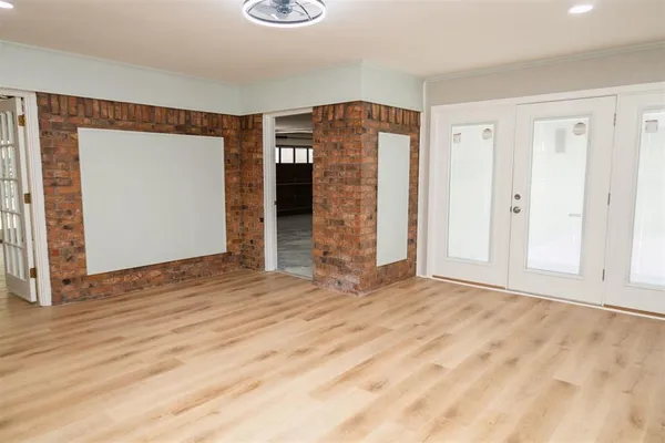 a view of an empty room with wooden floor and entryway