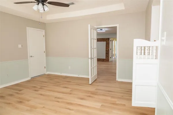a view of a hallway with a chandelier fan and wooden floor