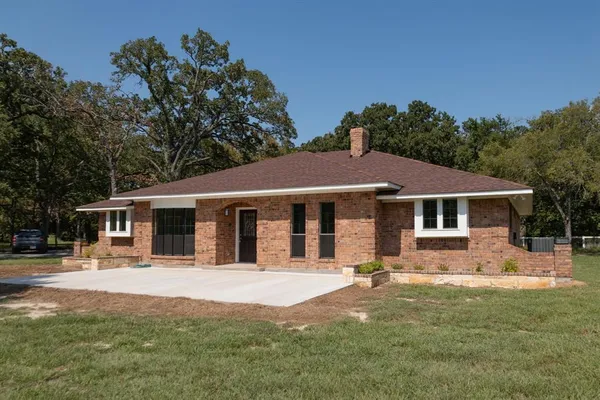 a front view of a house with a yard porch and tree