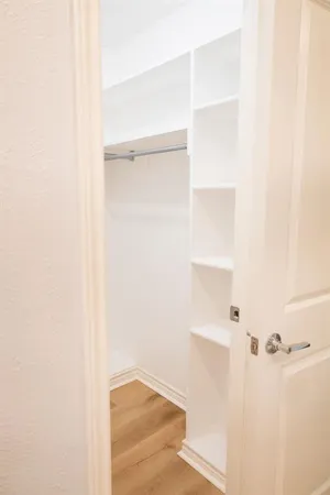a view of a big room with wooden floor closet and windows fan