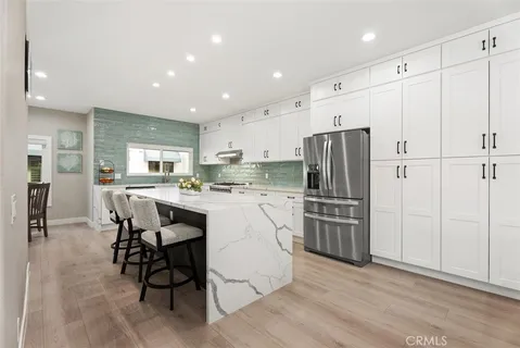 a kitchen with kitchen island white cabinets and stainless steel appliances