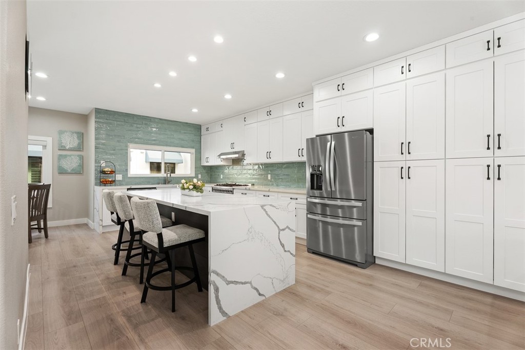 a kitchen with kitchen island white cabinets and stainless steel appliances