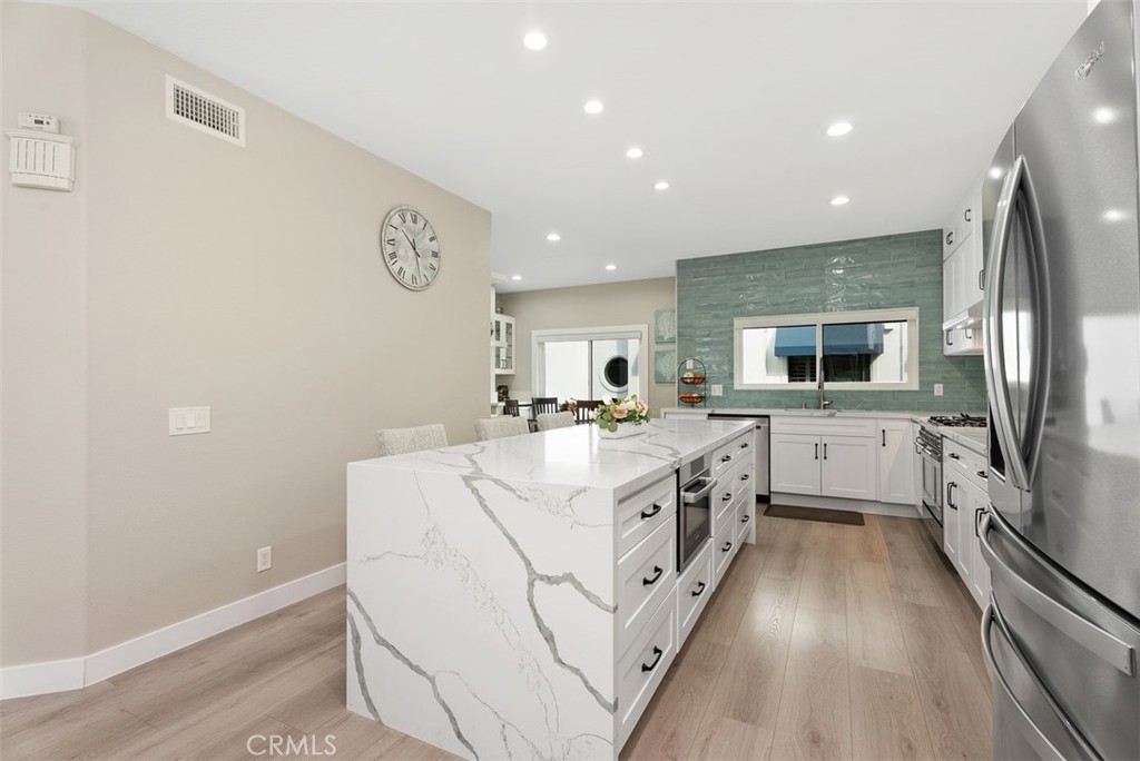 19502 Ranch Lane, Unit 112 Huntington Beach, CA 92648 - Photo 11 of 45 a large white kitchen with a stove top oven