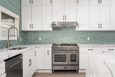 a kitchen with cabinets appliances and a sink