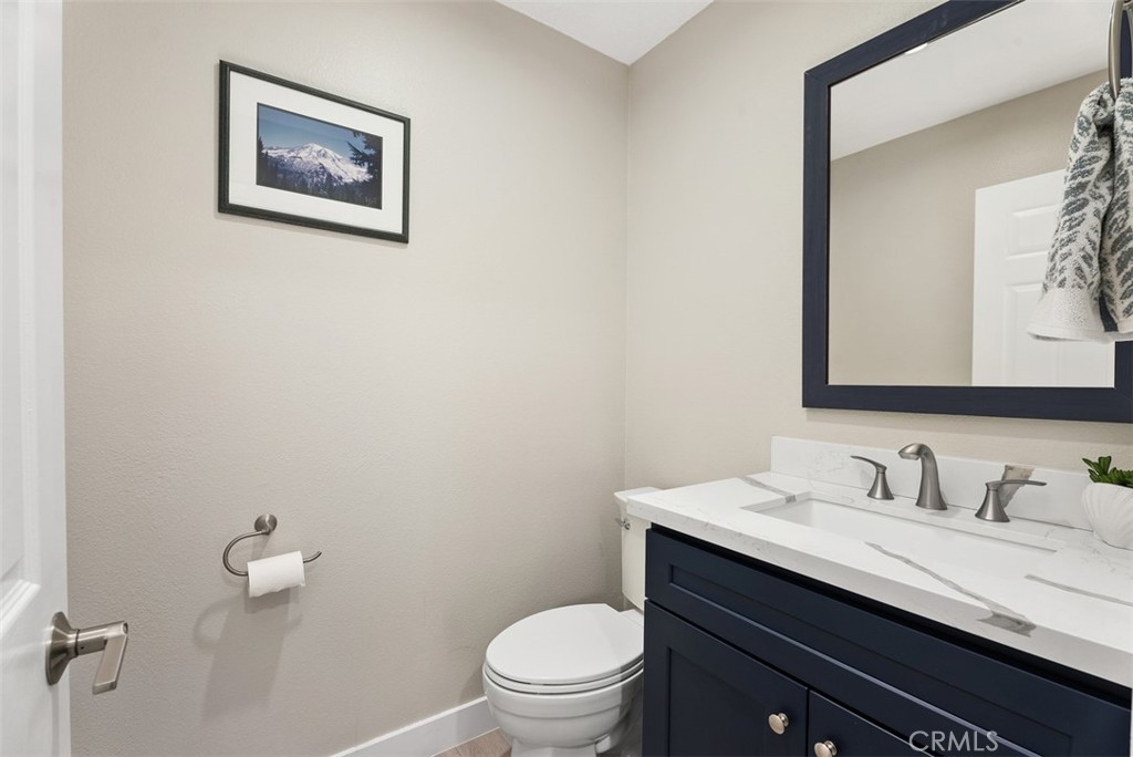 19502 Ranch Lane, Unit 112 Huntington Beach, CA 92648 - Photo 22 of 45 a bathroom with a granite countertop toilet sink and mirror