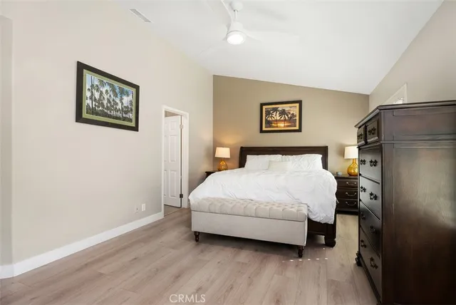 a spacious bedroom with a bed and a wooden floor