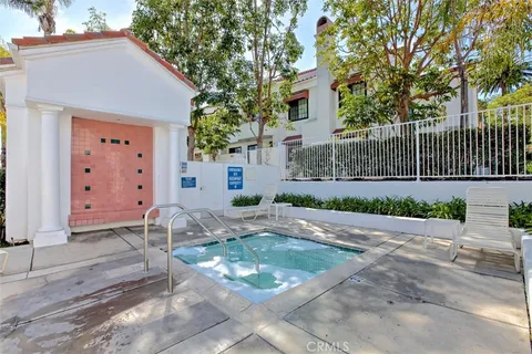 a backyard of a house with potted plants and large tree