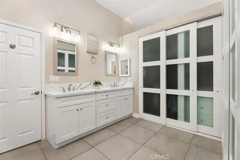 a spacious bathroom with a double vanity sink and a large mirror
