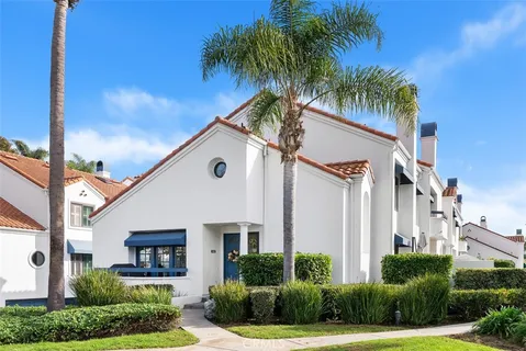 a view of a white house with a yard and potted plants